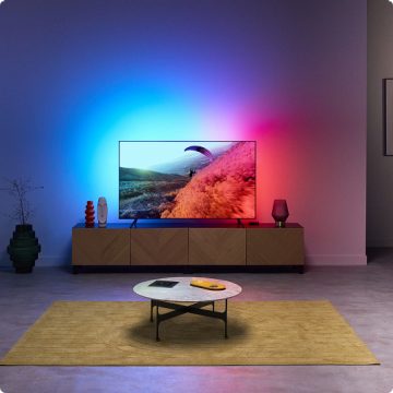A living room with immersive light coming from the TV Backlight, synced to the colours of the TV screen.