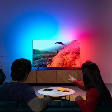 A couple enjoying LED light for TV with colors synced to the screen.